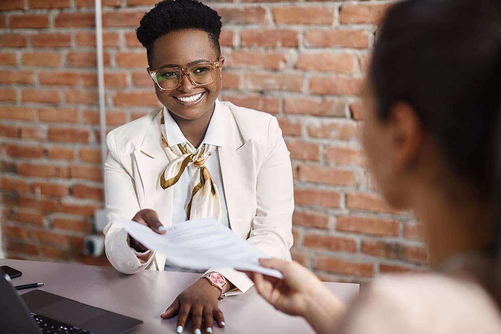 Human resource manager takes CV from a candidate during job interview in the office.